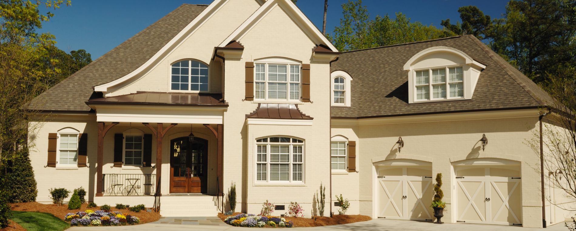 A view to home exterior with a double garage door